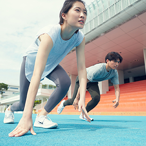 image of female & male student running at the stadium